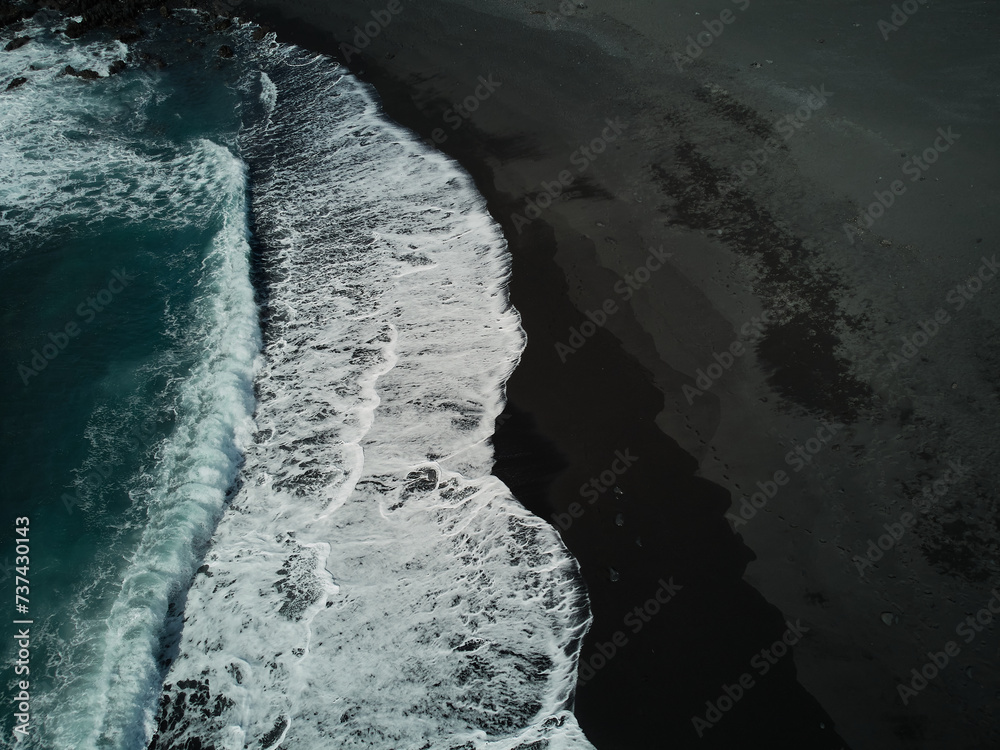 Waves and black sand beach on the shore of the Atlantic Ocean in Lanzarote Spain