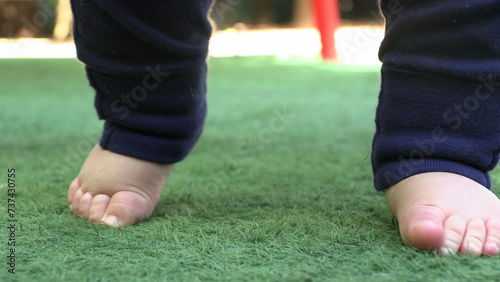 Closeup of baby infant feet outside standing trying to be balance