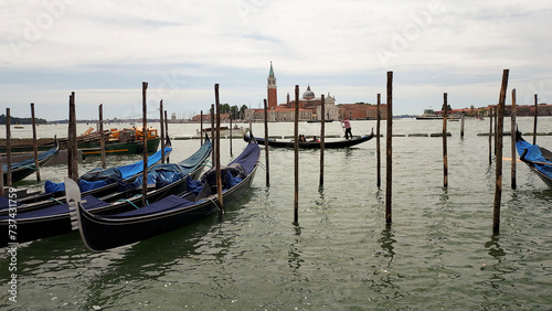 Venetian religious green lantern and gondolas docked by wooden mooring poles in Grand Canal with the Basilica Di Santa Maria Della Salute in background, near Piazza San Marco, Venice, Italy.  © KABUGUI