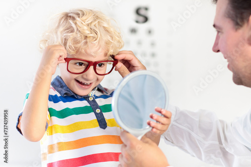 Child at eye sight test. Kid at optitian. Eyewear for kids. photo