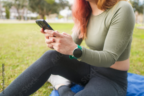 Woman checking her phone at the park