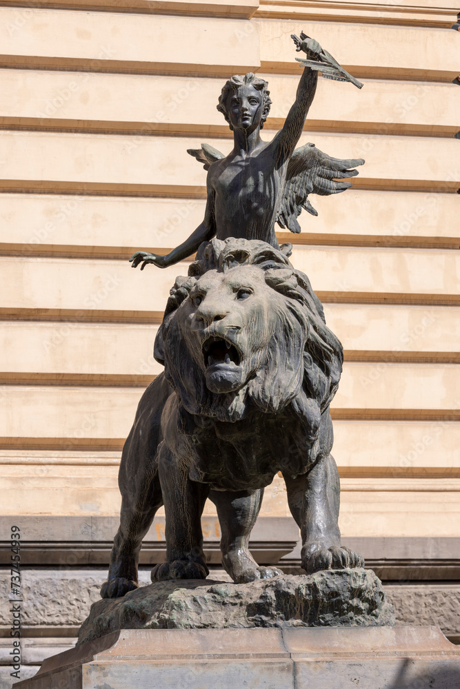 Lion and winged genius statues in front of Palazzo della Borsa, Naples, Italy