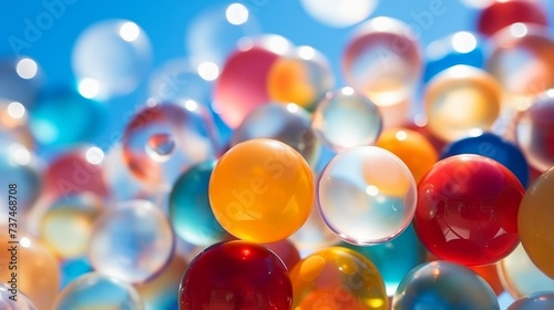 Colorful transparent bouncy balls floating in mid air with a blue sky in the background