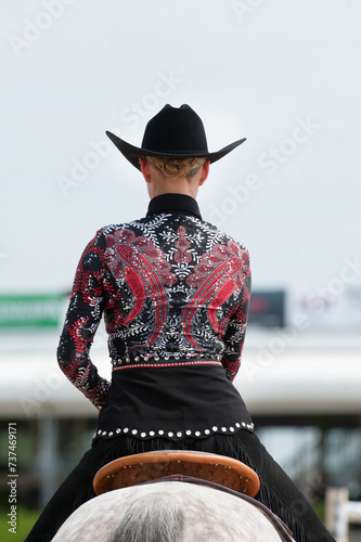 western horse show attire female horse rider wearing bright shirt with bling and western fashion pattern western pleasure horse show apparel for horse show competition in  western riding vertical 