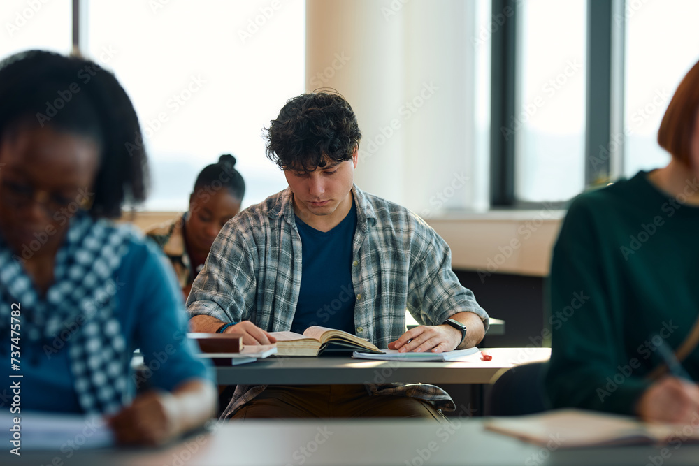 Young student learning at university library. Young student learning at university library.