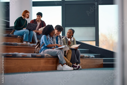 Multiracial group of university friends studying in lecture hall at campus. photo