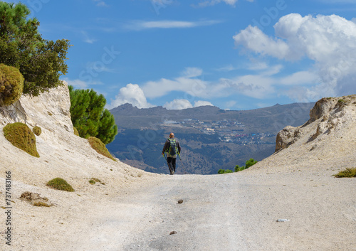 Hiker with the Prado Llano ski resort of Sierra Nevada in the distance