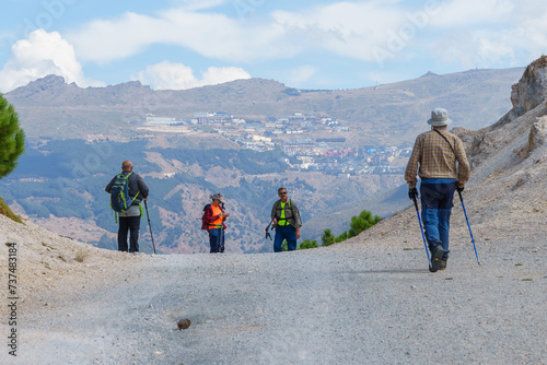 Hikers on Mountain Trail with Prado Llano Ski Resort in View