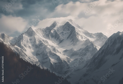 Majestic mountain peaks with snow-capped summits and clouds above © FrameFinesse