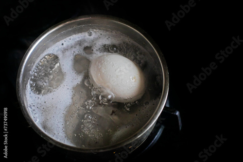 cook a chicken white egg in boiled water in a saucepan at home