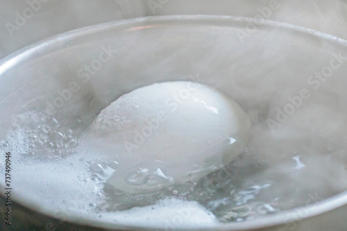 close-up of a chicken white egg boiled in boiled water