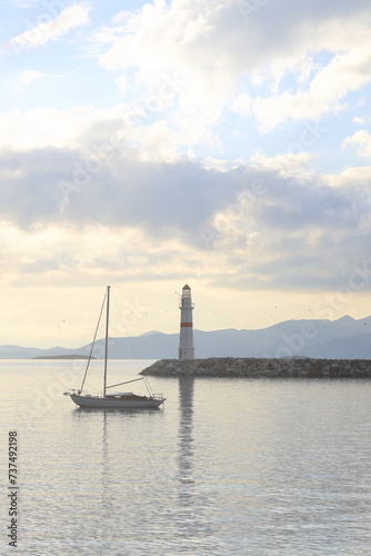 Seascape at sunshine. Lighthouse and sailings on the coast. Seaside town of Turgutreis and spectacular sunshine