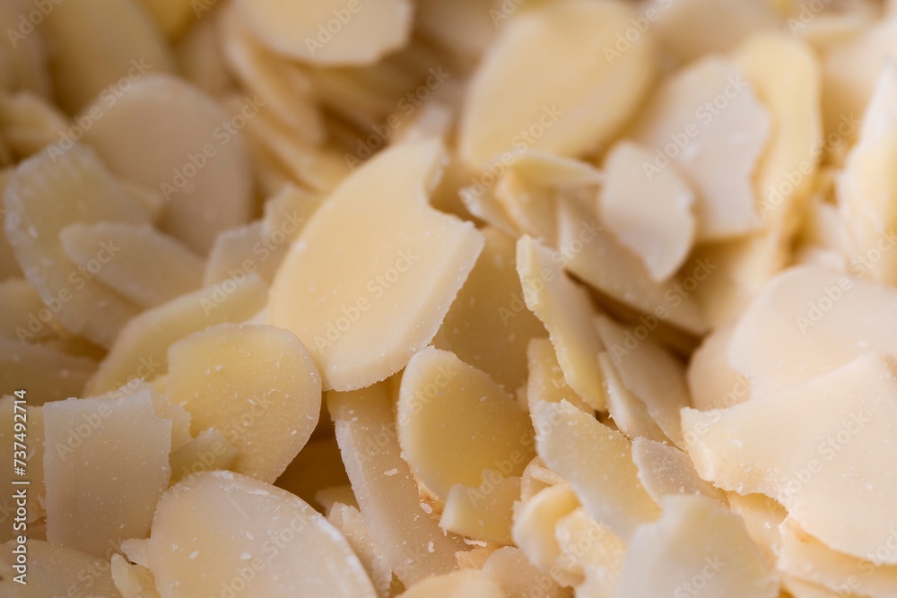 A tasty macro portrait of a pile full of almond flakes used by a baker to create tasty cookies or pastries. The chopped up crunchy cooking and baking ingredient is ready to be used. A tasty macro portrait of a pile full of almond flakes used by a baker to create tasty cookies or pastries. The chopped up crunchy cooking and baking ingredient is ready to be used.