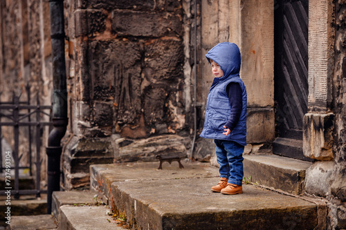 Young Child Exploring Historic Stone Steps in a Blue Hooded Vest
