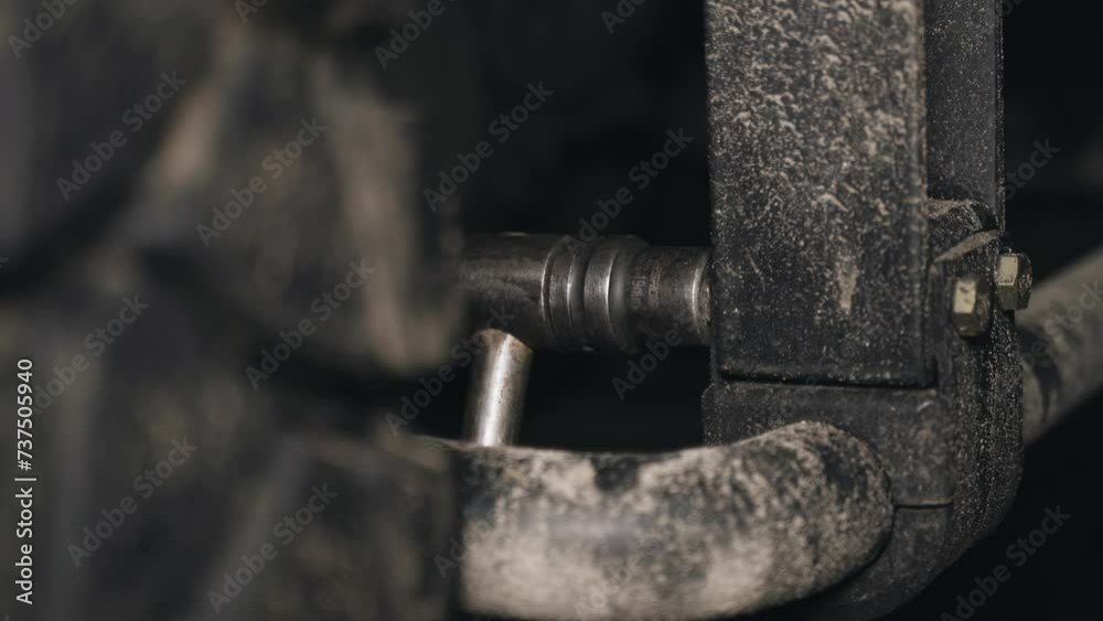 A mechanic tightens bolts with a wrench on the units and parts of a truck in a repair shop. Close-up. A mechanic tightens bolts with a wrench on the units and parts of a truck in a repair shop. Close-up.