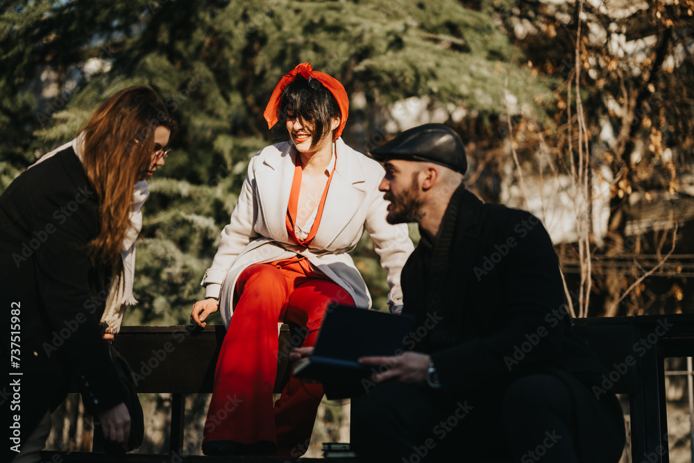 Obraz premium A vibrant group of young entrepreneurs engage in a creative brainstorming session outside amidst the buzz of city life, discussing strategies for success.