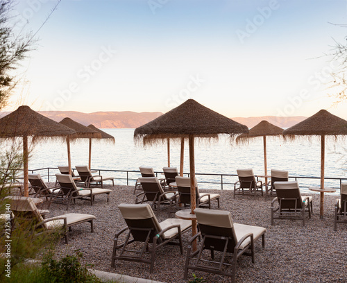 Straw beach umbrellas on the beach of Rabac  Croatia