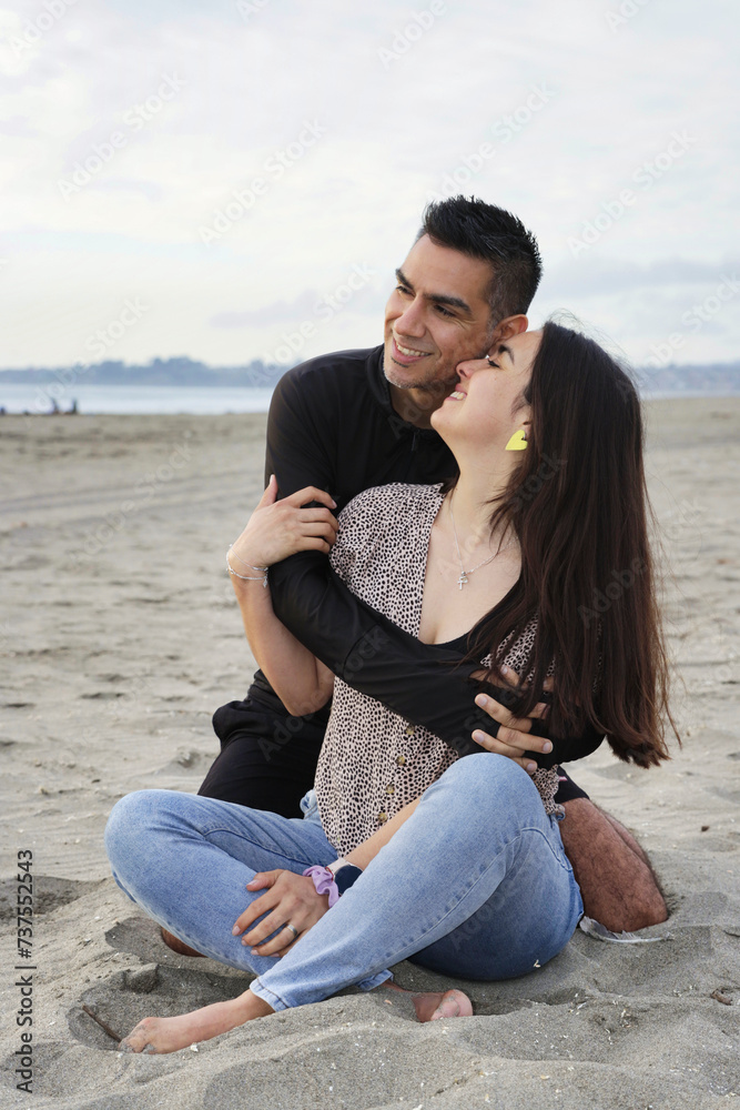 Pareja de enamorados se abrazan en la playa