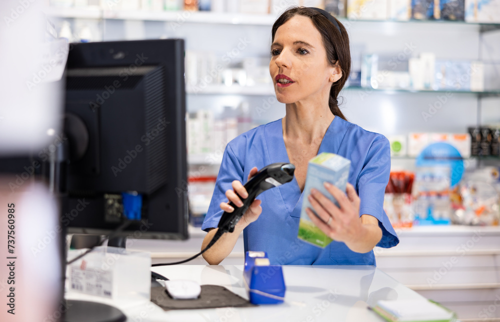 Female pharmacist scans the barcode of product at the checkout in a pharmacy