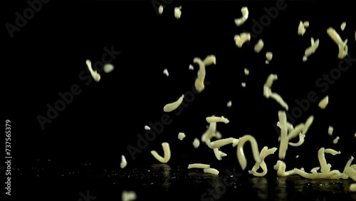 Shredded cheese falling on black background. Filmed on a high-speed camera at 1000 fps. High quality FullHD footage photo