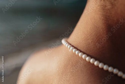 close up of a faceless person with perls at the beach in Sifnos island, Cyclades, Greece