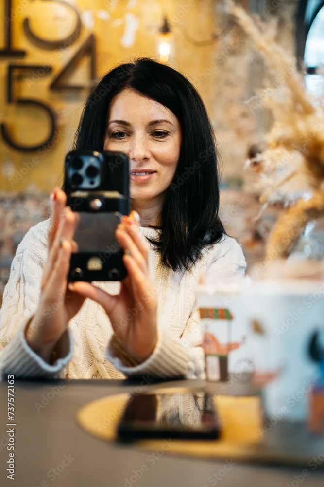 A young beautiful woman takes a selfie in a cafe. A young beautiful woman takes a selfie in a cafe.
