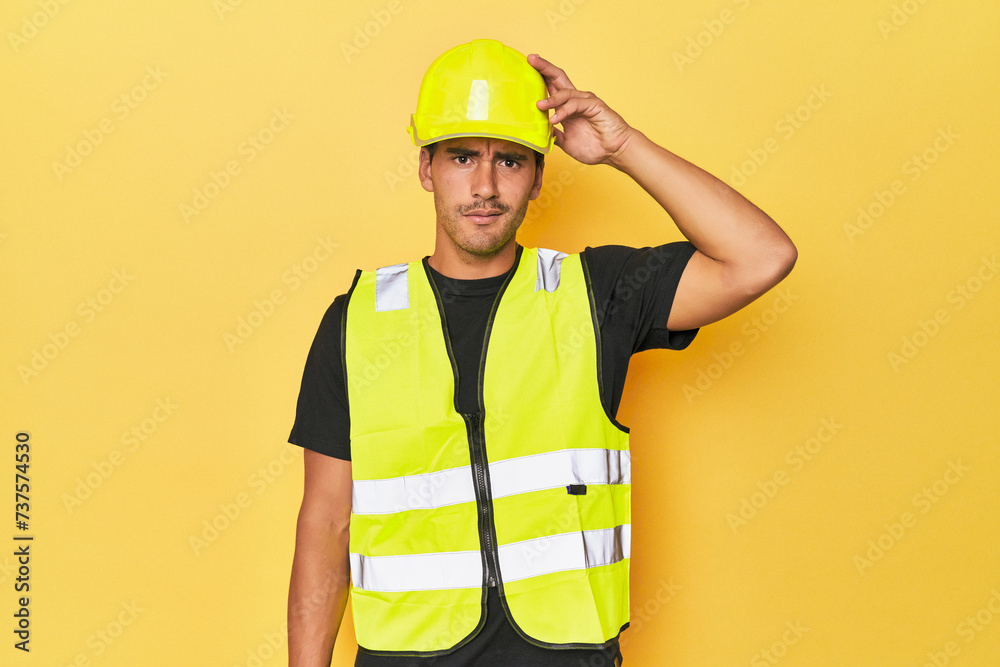 Latino worker in yellow vest and helmet being shocked, she has remembered important meeting. Latino worker in yellow vest and helmet being shocked, she has remembered important meeting.