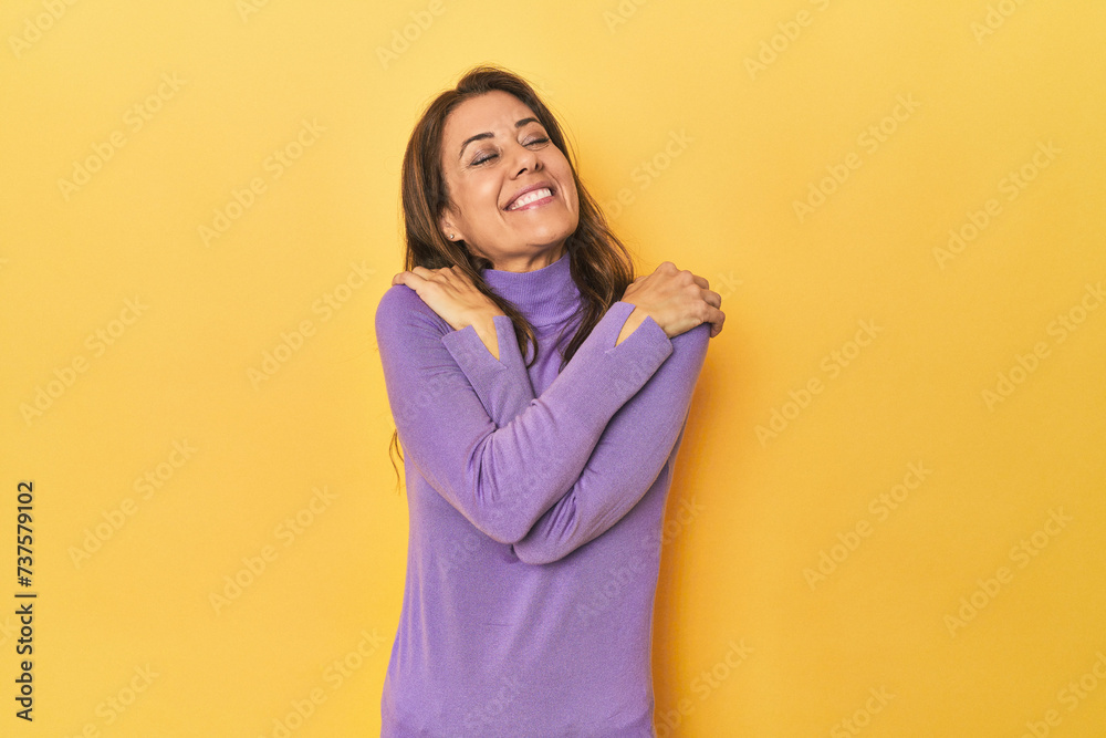 Middle-aged caucasian woman on yellow hugs, smiling carefree and happy. Middle-aged caucasian woman on yellow hugs, smiling carefree and happy.