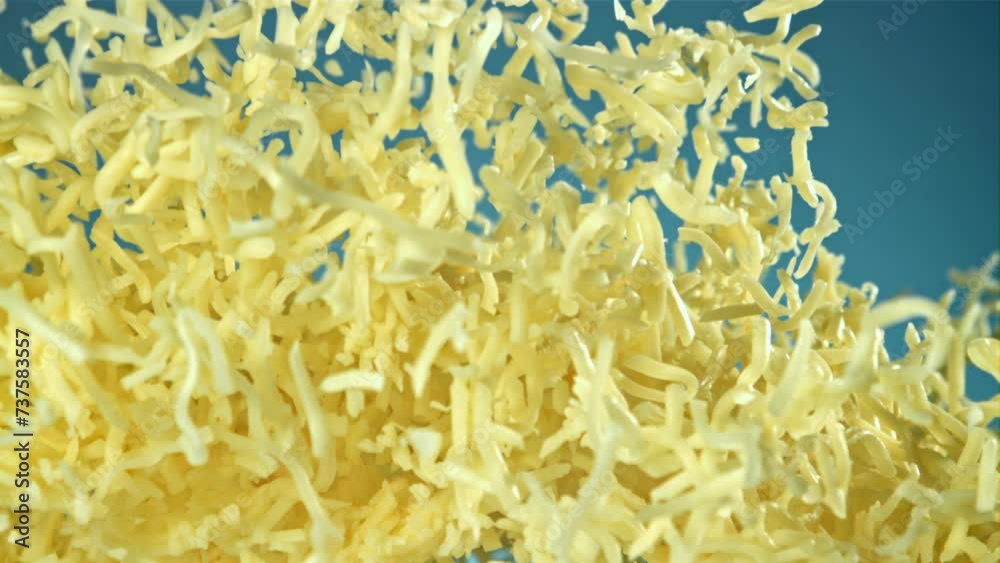 Shredded cheese flies up. On a blue background. Filmed on a high-speed camera at 1000 fps. High quality FullHD footage