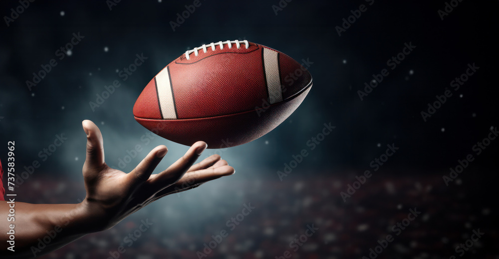 Dynamic Capture of Spiraling Football Approaching Receiver's Outstretched Hand Under Stadium Lights. American football