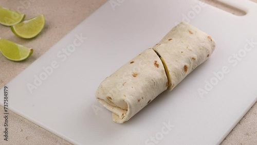 Cutting a breakfast burrito in half, burrito with scrambled egg, cheese and sausage