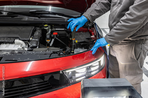 Headlight adjustment of the car in the car service. car repair shop worker checks and adjusts the headlights of a car's lighting system.
