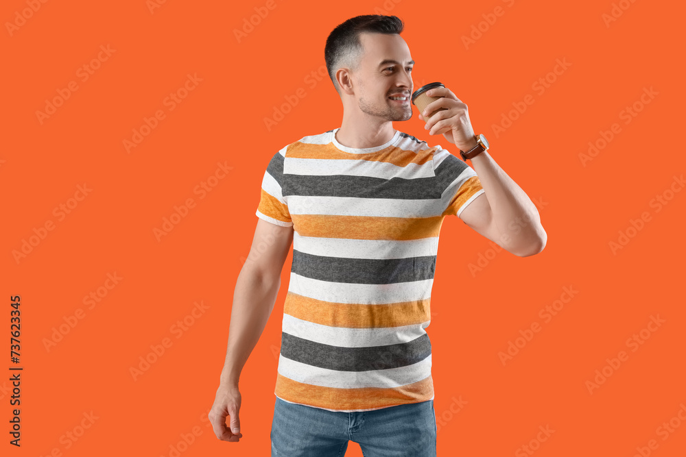 Happy young man drinking coffee on orange background Happy young man drinking coffee on orange background