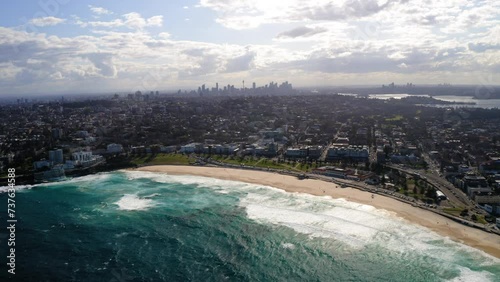 Aerial Panning Beautiful View Of Modern Suburb At Bondi Beach, Drone Flying Over Wavy Sea On Sunny Day - Sydney, Australia