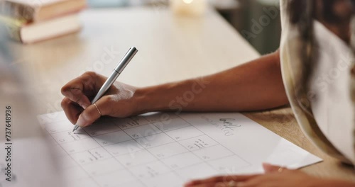 Hand, writing and calendar, plan schedule on desk and organization with timeline for tasks or event. Priority, agenda and goals with person for productivity, time management and reminder for deadline photo