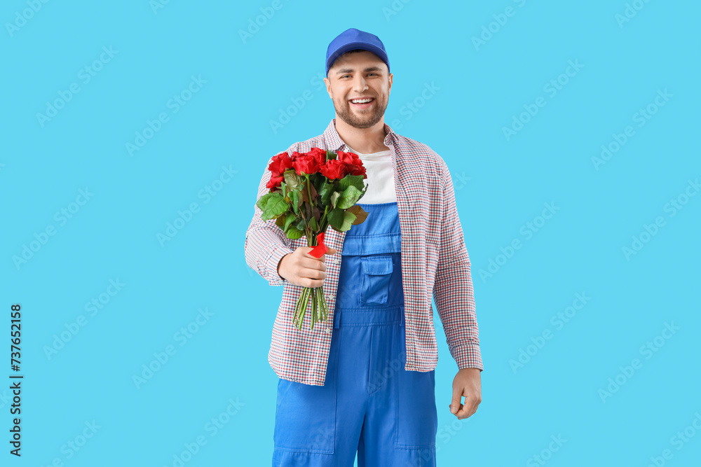 Male courier with bouquet of flowers on blue background Male courier with bouquet of flowers on blue background