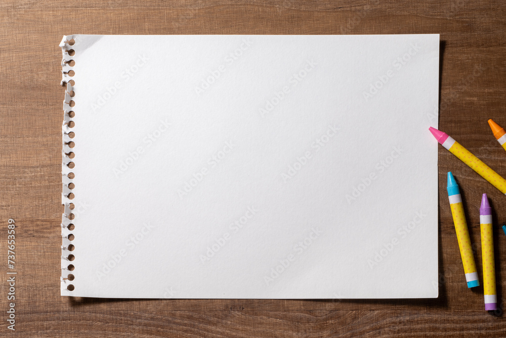 木製のテーブルの上にある一枚の画用紙とクレヨン 木製のテーブルの上にある一枚の画用紙とクレヨン