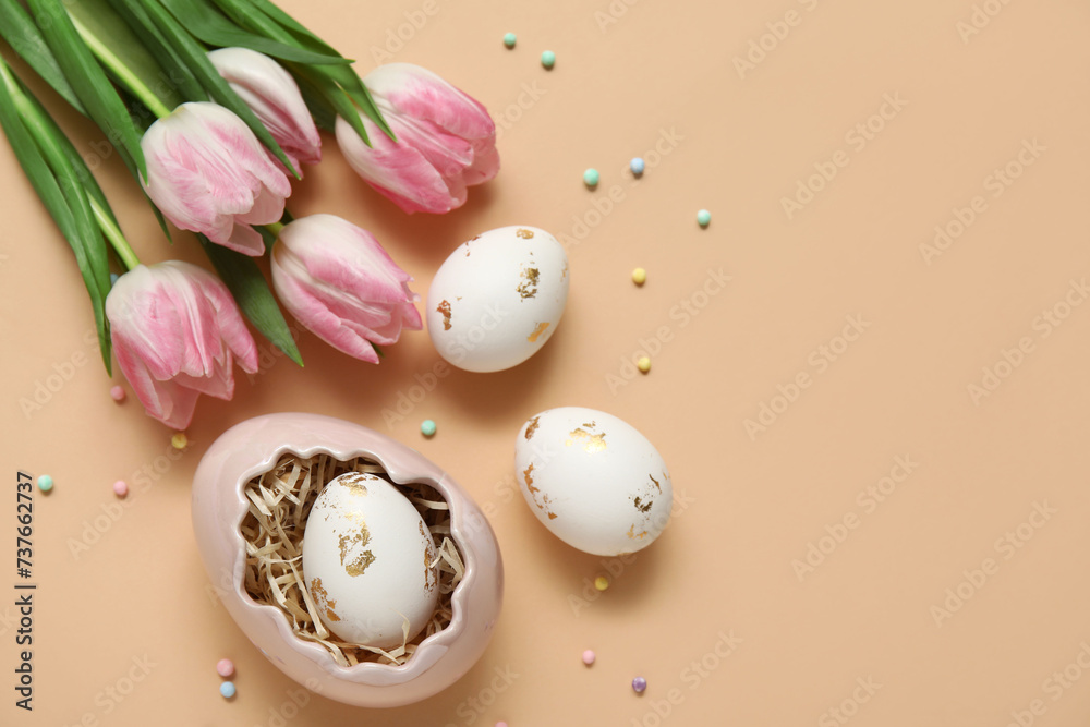 Easter eggs with sprinkles and tulips on beige background