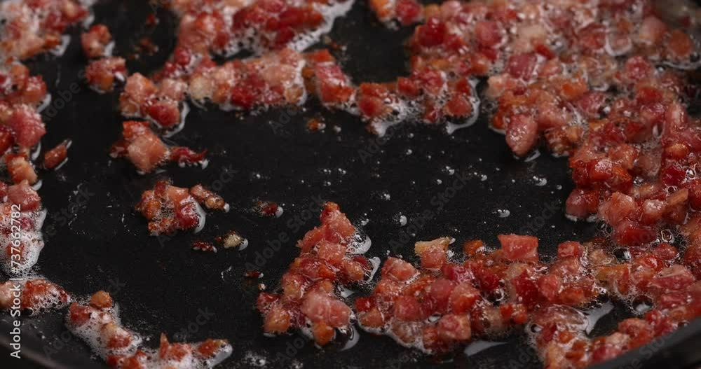 Cooking bacon or prosciutto in a skillet, stirring with a wooden spoon