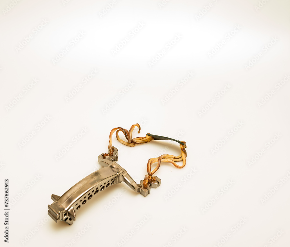 Studio shot of well-used metal slingshot isolated against a white background. Studio shot of well-used metal slingshot isolated against a white background.