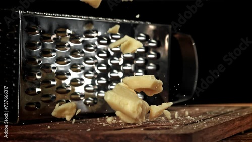 Parmesan cheese falls on a wooden board. Filmed on a high-speed camera at 1000 fps. High quality FullHD footage photo