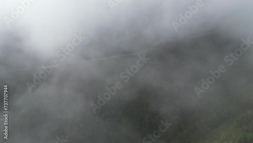 Aerial flight through cloud to famous Death Road in Bolivia mountains photo