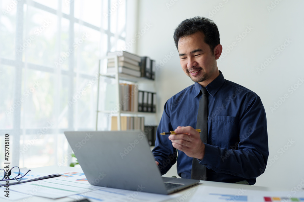 Asian businessman points at laptop computer screen to calculate budget, financial statistics and discuss financial services and management issues. Asian businessman points at laptop computer screen to calculate budget, financial statistics and discuss financial services and management issues.