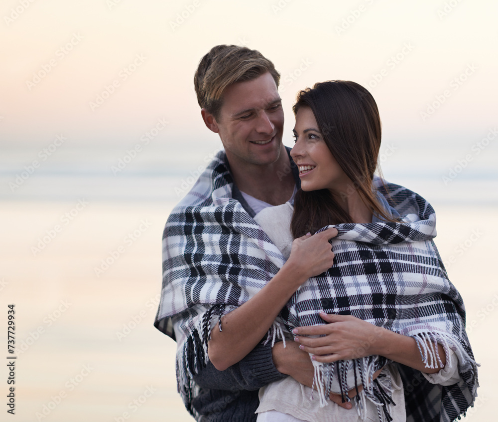 Couple, hug and sunset at beach with blanket for vacation, love and care in nature, outdoor and ocean. Man, woman and embrace with smile, bonding and happy for memory on holiday by sea in Australia Couple, hug and sunset at beach with blanket for vacation, love and care in nature, outdoor and ocean. Man, woman and embrace with smile, bonding and happy for memory on holiday by sea in Australia