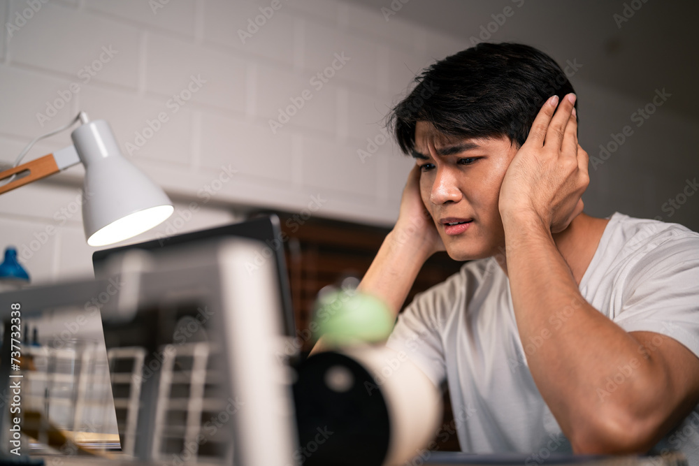 Asian depressed young man overworking alone on working table at night. Asian depressed young man overworking alone on working table at night.