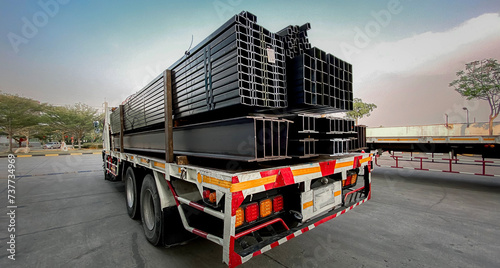 A truck with a long trailer carries rebar for building construction. Construction steel ready to be delivered to customers, steel transport vehicles