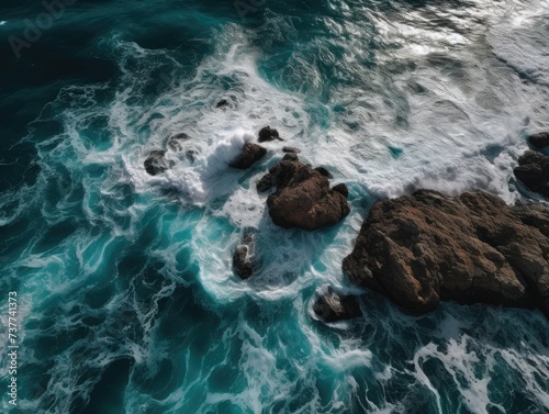 Waves crashing on the rocks on the shore, top view angle, coastline with rocks