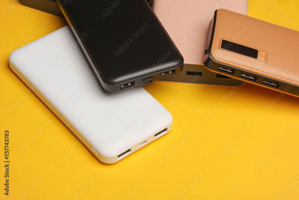 Different power banks (external batteries) on yellow background Different power banks (external batteries) on yellow background