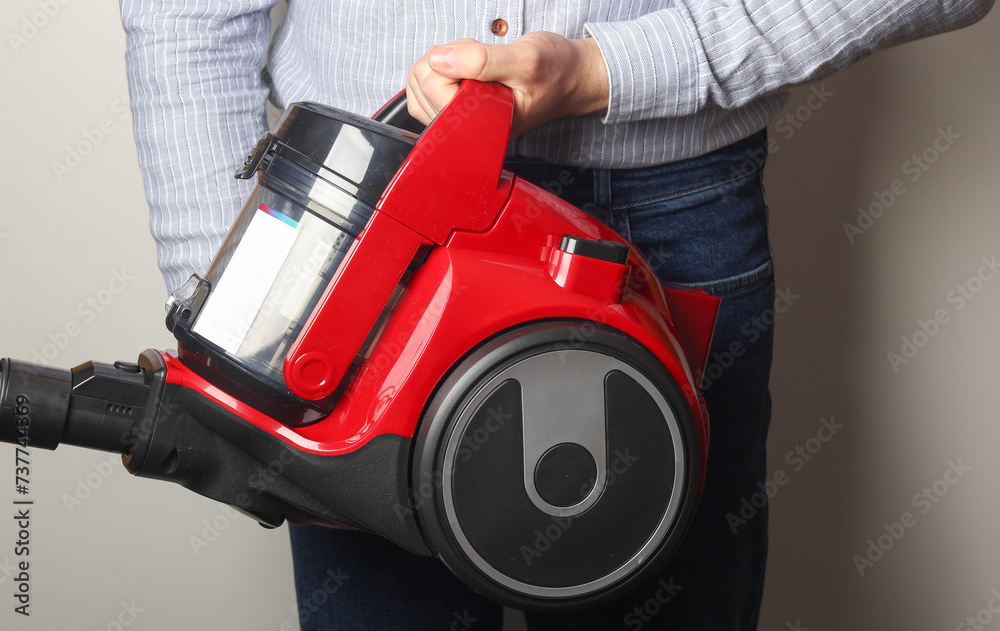 Fototapeta premium Man holding vacuum cleaner on white background