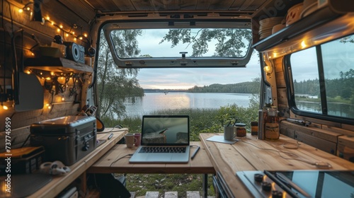 Vanlife workspace setup, laptop open with a view of a summer lake
